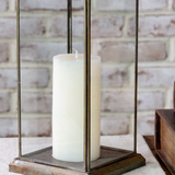 Decorative candle holder with a white candle on a textured surface