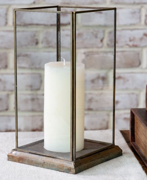 Decorative candle holder with a white candle on a textured surface