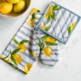 Set of kitchen towels and potholders with lemon design on a white surface.